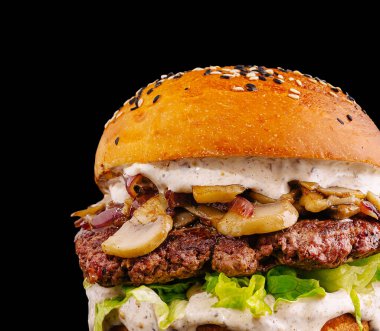 Sotelenmiş mantar ve taze marullu ızgara biftekli leziz bir hamburger.