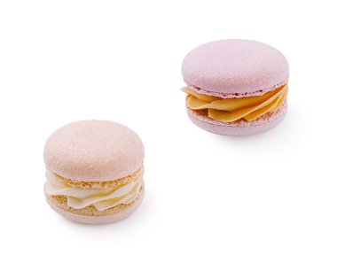 İki pastel badem kurabiyesi beyaz bir yüzeyde çok güzel durur. Birinde krema dolgusu var, diğerinde ise meraklılar için lezzetli tatlı seçenekleri var..