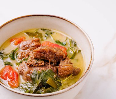 İçi taze et, canlı domates ve taze otlarla dolu taşralı bir kasede doyurucu bir sığır güveci kaynıyor. Bu yemek zengin tatlar ve renkli malzemeler sunar..