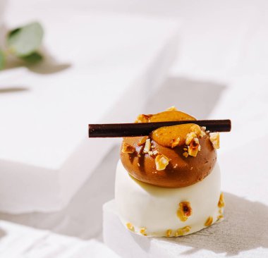 Çekici bir tatlı, çikolata katmanları ve kremalı karamel, ezilmiş fındık ve çikolata çubuğu ile vurgulanır..