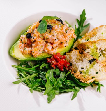 Elegant presentation of avocado and salmon tartare with arugula and toasted bread