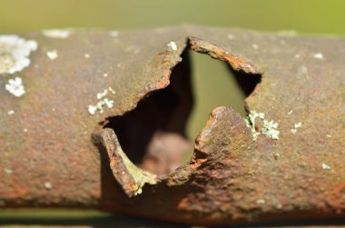 Paslı boru ile bir delik. Eski bir çit bir parçası.