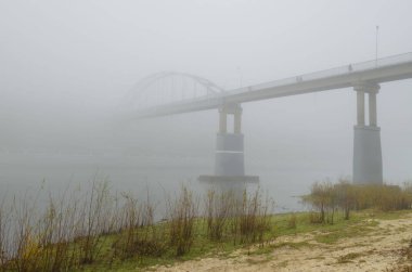 Nehri üzerinde yoğun bir sis var. Uzaktan köprü anahat görebilirsiniz.