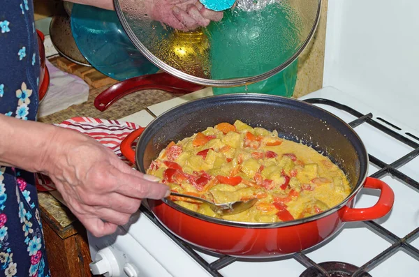 The hostess puts out the vegetables on a gas stove.It turned out a high-calorie dish rich in vitamins.