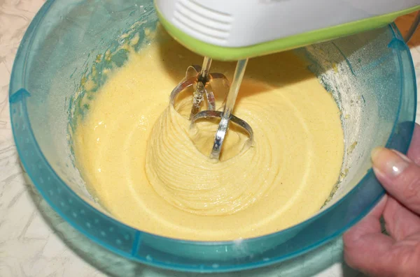 The dough for the pie with apples.Confectionery mixture is whipped with an electric mixer.