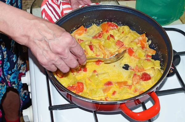 The hostess puts out the vegetables on a gas stove.It turned out a high-calorie dish rich in vitamins.