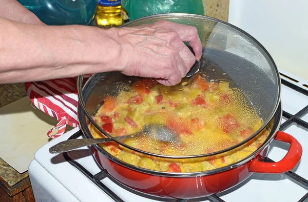 The hostess puts out the vegetables on a gas stove.It turned out a high-calorie dish rich in vitamins.