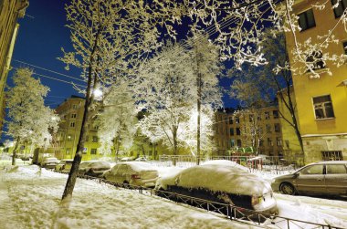 Gece şehirde kış. Dışarısı. Kar bir sürü.