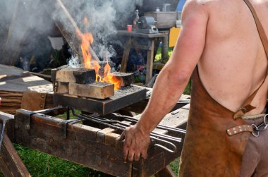 demirci metal işleme ustasıdır. Sıcak metal ilerler ve ondan ürünler yapar..