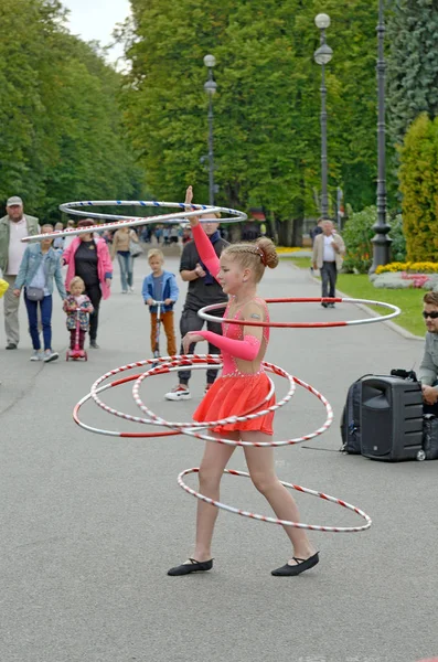 The girl twists the hoop with her body. — Stock Photo, Image