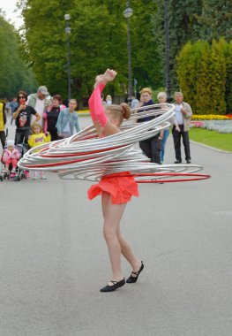 Kız vücuduyla çemberi bükürür..