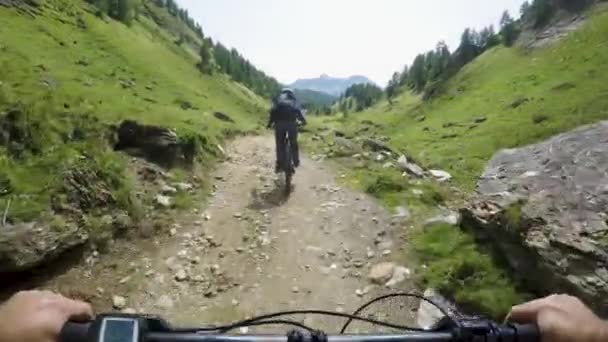 POV muž na koni e kolo po přítele žena. MTB akce cyklista zkoumání společně horská stezka cesta. Elektrické kolo aktivních lidí sport cestování dovolená v Alpách Itálie venku v summer.4k video — Stock video