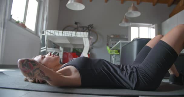 Νέοι τατουάζ γυναίκα κάνει δυστοκίες άσκηση stretching κατά τη διάρκεια του γυμναστηρίου Αθλητισμός προπόνηση στο σπίτι. λεπτομέρεια στο πλάι. Καθιστικό εσωτερικού κατάρτισης. 4 k βίντεο αργής κίνησης — Αρχείο Βίντεο