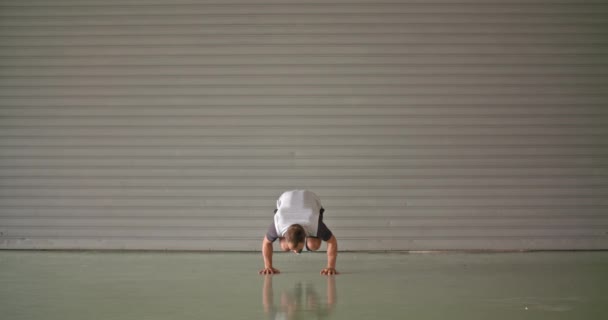 Homem adulto jovem fazendo exercício de suporte de mão durante o treino esportivo de fitness .Grunge industrial urbano training.4k vídeo em câmera lenta — Vídeo de Stock