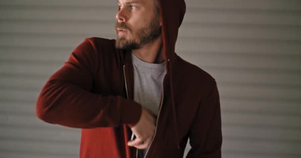 Jonge volwassen man met hooded sweatshirt met smartphone tijdens sport fitnesstraining. Grunge industriële stedelijke training.4k slowmotion video — Stockvideo