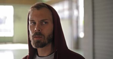 Kapüşonlu sweatshirt içme suyu fitness spor egzersiz sırasında dinlenme ile genç yetişkin adam. Grunge endüstriyel kentsel training.4k ağır çekim video