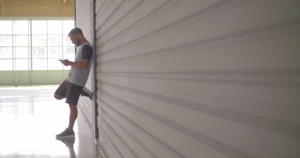 青年男子使用智能手机跟踪应用程序在健身运动锻炼 垃圾工业城市训练 慢动作视频 — 图库视频影像