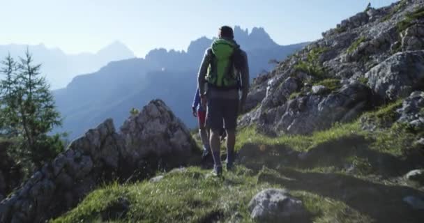 Four friends walking along hiking trail path. Group of friends people summer adventure journey in mountain nature outdoors. Travel exploring Alps, Dolomites, Italy. 4k slow motion 60p video — Stock Video