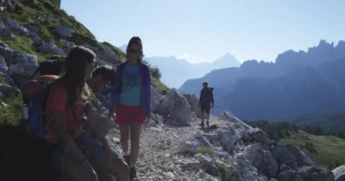 Dört arkadaş yürüyüş boyunca yürüyüş yolu iz ve rahatla. Grup arkadaşları insanların yaz macera yolculuğun dağ doğa açık havada. Alpler, Dolomites, İtalya keşfetmek seyahat. 60 p video 4k yavaş hareket