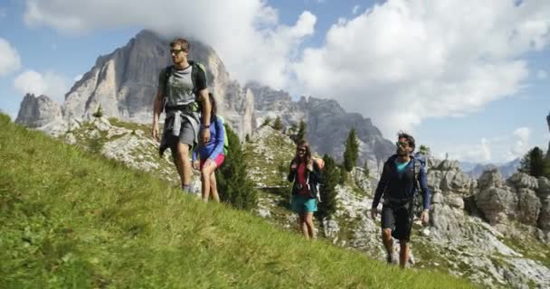 Τέσσερις φίλοι περπατώντας άγρια πεζοπορία μονοπάτι μονοπάτι. Ομάδα φίλων άτομα καλοκαιρινή περιπέτεια ταξίδι στην ορεινή φύση σε εξωτερικούς χώρους. Ταξίδια εξερεύνησης Άλπεις, Δολομίτες, Ιταλία. 4k αργή κίνηση βίντεο 60p — Αρχείο Βίντεο