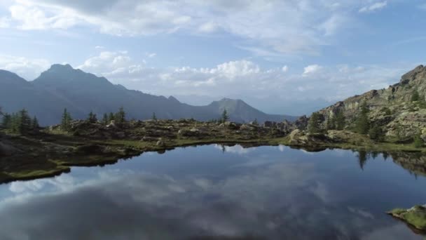 Moving forward above clear blue lake and pine woods in sunset summer day.Europe Italy Alps Valle dAosta outdoor green nature scape mountains wild aerial establisher.4k drone flight establishing shot — Stock Video