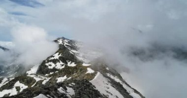 Bulutlu karlı Felsberg güneşli gün ile bulutlar üzerinde ileri hava üstten görünüm. İtalyan Alpleri dağlarda vahşi rüzgarlı hava açık doğa establisher.4k drone uçuş atış kurulması ile yaz