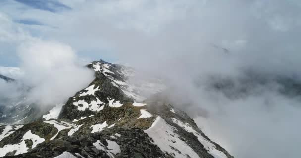 Vista superior aérea hacia adelante sobre la montaña nevada rocosa nublada en el día soleado con nublas.Montañas de los Alpes italianos en verano con viento salvaje naturaleza al aire libre Establecimiento de vuelo drone 4k establecer tiro — Vídeos de Stock