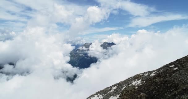 Para a frente vista aérea superior sobre a montanha nevada rochosa nevada nublada no dia ensolarado com montanhas clouds.Italian alpes no verão com tempo vento selvagem natureza ao ar livre establishment .4k voo drone que estabelece tiro — Vídeo de Stock