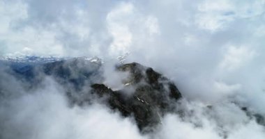Bulutlu karlı Felsberg güneşli gün ile bulutlar üzerinde ileri hava üstten görünüm. İtalyan Alpleri dağlarda vahşi rüzgarlı hava açık doğa establisher.4k drone uçuş atış kurulması ile yaz