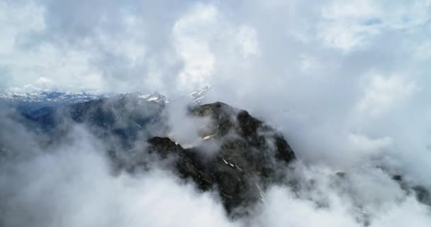 Vista superior aérea hacia adelante sobre la montaña nevada rocosa nublada en el día soleado con nublas.Montañas de los Alpes italianos en verano con viento salvaje naturaleza al aire libre Establecimiento de vuelo drone 4k establecer tiro — Vídeo de stock