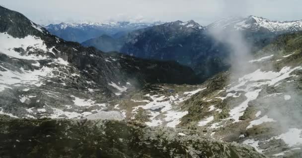 Πλευρά επάνω Αεροφωτογραφία πάνω από θολό βραχώδη χιονισμένο βουνό στην ηλιόλουστη ημέρα με σύννεφα. Ιταλικές Άλπεις βουνά το καλοκαίρι με drone establisher.4k εξωτερική φύση άγρια θυελλώδεις καιρικές συνθήκες πτήσης για την ίδρυση βολή — Αρχείο Βίντεο