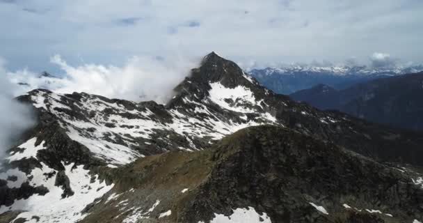 Bulutlu karlı Felsberg güneşli gün ile bulutlar üzerinde ileri hava üstten görünüm. İtalyan Alpleri dağlarda vahşi rüzgarlı hava açık doğa establisher.4k drone uçuş atış kurulması ile yaz — Stok video