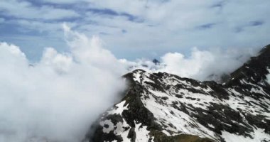 Bulutlu karlı Felsberg bulutlar ile güneşli gün üzerinden geriye doğru hava üstten görünüm. İtalyan Alpleri dağlarda vahşi rüzgarlı hava açık doğa establisher.4k drone uçuş atış kurulması ile yaz