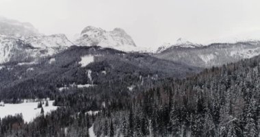 İleri Hava karlı dağ ile ormanda orman üzerinde. Bulutlu kötü sisli hava bulutlu. Kış Dolomites İtalyan Alpleri dağlar açık doğa establisher.4k drone uçuş atış kurulması