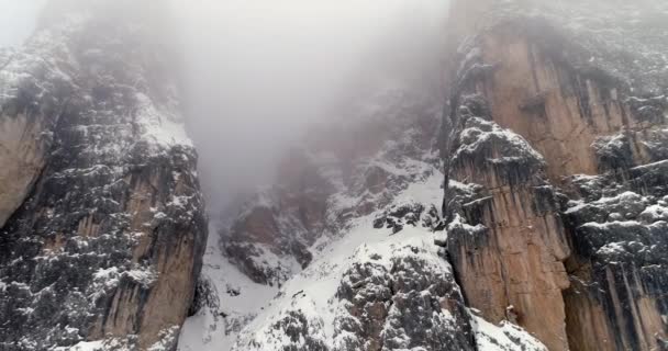 Visszafelé javításához a sziklás havas dönthető le. Felhős rossz borús ködös időjárás. Tél olasz dolomit hegyek szabadtéri establisher.4k drone repülés — Stock videók