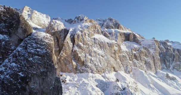 Achterwaartse antenne langs de vallei van de besneeuwde Alpen steile rotsachtige klip. Zonnige dag, heldere hemel. Winter Dolomieten Italiaanse Alpen bergen buiten natuur establisher.4k drone vlucht — Stockvideo