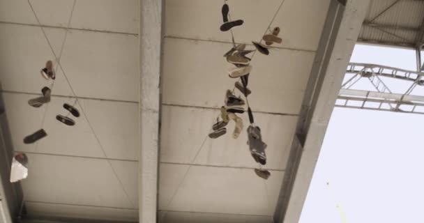 Shoes hanging on electrical cables in urban concrete  environment.4k slow motion 60p video — Stock Video