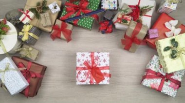 Ana hediye alarak genel gider kişi eller bırakarak metin veya logo kopya alanı mevcut. Ahşap masa Noel hediye kutuları tam dikey üstten görünüm. Xmas tatil sezonu sosyal kartı background.4k video