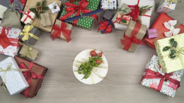 Χέρια γενικά άτομο που λαμβάνοντας το κύριο δώρο παρουσιάσει αφήνοντας χώρο αντιγραφή κειμένου ή το λογότυπο. Κάθετη κάτοψη του ξύλινο τραπέζι γεμάτο κουτιά δώρου Χριστουγέννων. Χριστουγεννιάτικες διακοπές σεζόν κοινωνικής κάρτας background.4k βίντεο — Αρχείο Βίντεο