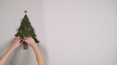 Genel gider kişi eller doğal Noel ağacı çam süsleme karton metin veya logo ile ışıkları ile hazırlama alanı kopyalayın. Dikey üstten görünüm. Xmas tatil sezonu sosyal kartı background.4k video