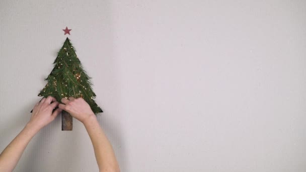 头顶的人手准备自然圣诞树松木装饰与灯在纸板与文本或徽标复制空间。垂直顶部视图。圣诞节假日季节社会卡背景. 4 k 视频 — 图库视频影像