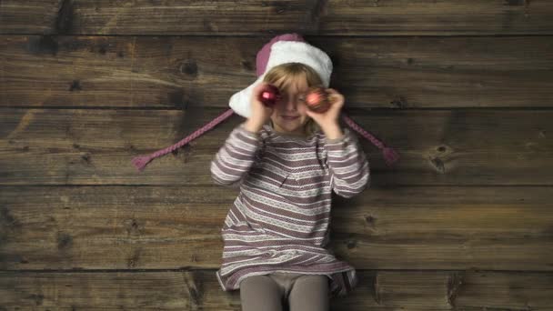 Ragazza sorridente felice sopraelevata con cappello che gioca con decorazioni su sfondo vintage in legno.Testo o logo copiare spazio.Verticale vista dall'alto. — Video Stock