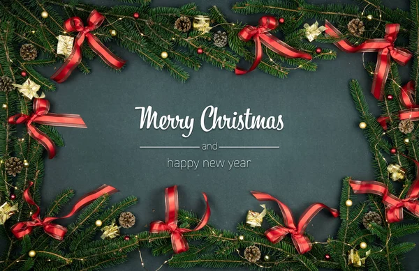 メリー クリスマスと幸せな新年のご挨拶松の枝、リボン ライトと上部の垂直ビュー暗い黒板では、フレームを装飾されています。クリスマス冬のホリデー シーズンのソーシャル メディア カード背景 — ストック写真