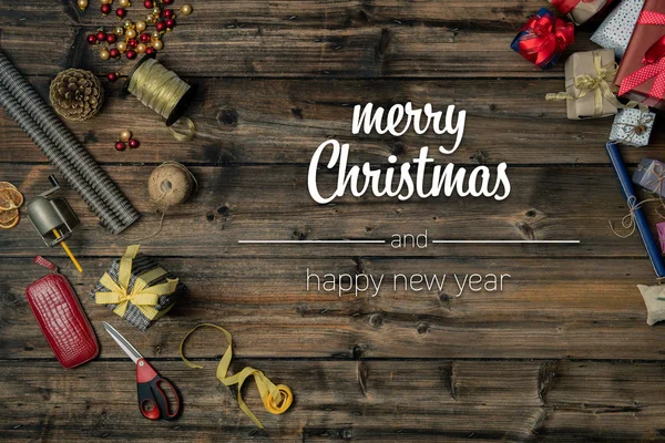 Merry Christmas and happy new year greetings in vertical top view vintage wood.handicraft tools,ribbons,gift present boxes decorated frame.Xmas winter holiday season social media card background