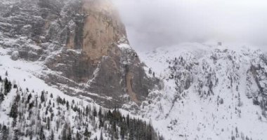 Karlı dağ ve Sella pass, ormanda orman ile geriye dönük anteni. Bulutlu kötü sisli hava bulutlu. Kış Dolomites İtalyan Alpleri dağlar açık doğa establisher.4k drone uçuş