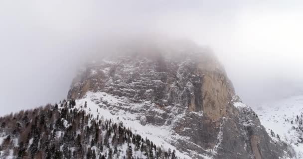 Aérien arrière avec montagne enneigée et forêt boisée au col Sella. Nuageux mauvais temps brouillard couvert. Hiver Dolomites Alpes italiennes montagnes nature en plein air Establisher.4k vol de drone — Video