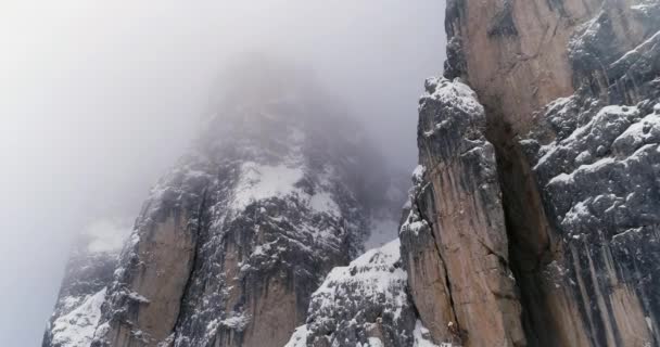 雪に覆われた岩山に前方の空中。曇り曇り霧悪天候。冬ドロミテ イタリア アルプス山脈屋外の自然 establisher.4k 無人飛行 — ストック動画