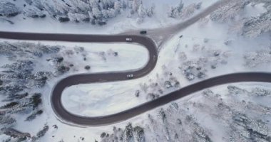 Saç tokası yukarıda ek yükü dikey hava arabalar, ormanda karlı ormanı olan yol açın. Gün batımı veya gündoğumu. Kış Dolomites İtalyan Alpleri dağlar açık doğa establisher.4k drone uçuş atış kurulması.