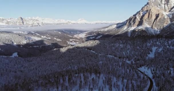 Előre légi havas erdő erdő és közúti Valparola pass-völgy. Napos naplemente vagy napfelkelte, tiszta ég. Tél olasz dolomit hegyek szabadtéri establisher.4k drone repülés — Stock videók