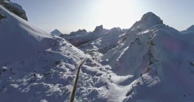 Hava yolu yukarıda Valparola pass, karlı vadi boyunca İleri. Güneşli gün batımı veya gündoğumu, gökyüzü temizleyin. Kış Dolomites İtalyan Alpleri dağlar açık doğa establisher.4k drone uçuş atış kurulması
